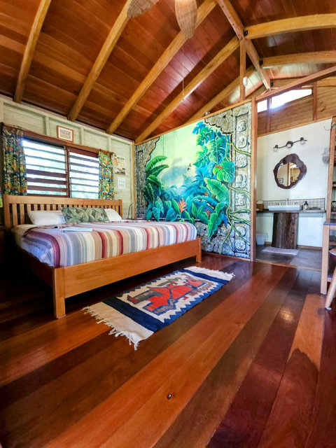 Bedroom features a King bed and hand-painted mural by local artists.