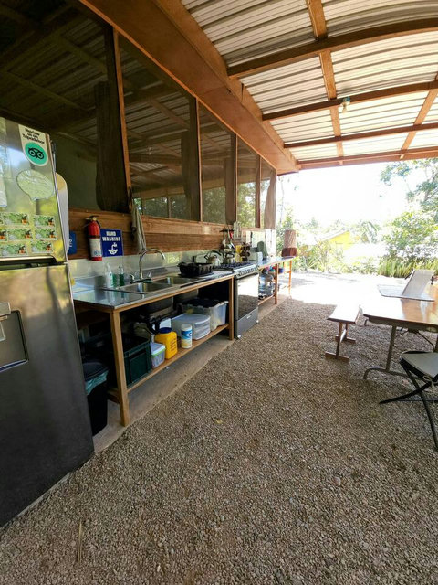 Shared outdoor kitchen - includes 6 burner stovetop, full-size frig/freezer and double sink with plenty of counter space and a charcoal grill!