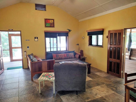 Living room with 2 twin day-beds & rocker/recliner, large live-edge custom made coffee table, desk & chair.  
