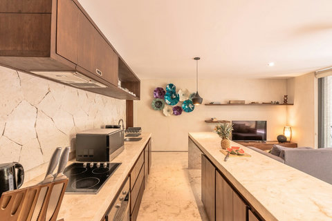 Kitchen with electric stove, oven, microwave, coffee maker, kettle, toaster & blender