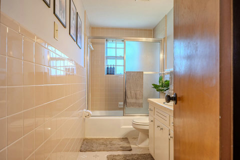 Full Bathroom 1 features a shower/tub combo, tasteful artwork, and is stocked with essentials like towels, soap, and shampoo. Clean, functional, and ready for a relaxing soak or quick refresh.