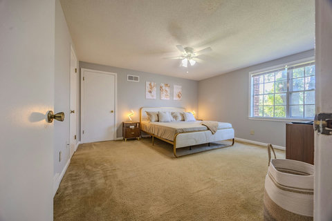 Unwind in the master suite with a king bed, smart TV, ceiling fan, and touch-control bedside lamps. A spacious closet and dresser provides ample storage, making this room perfect for relaxing and recharging during extended stays.