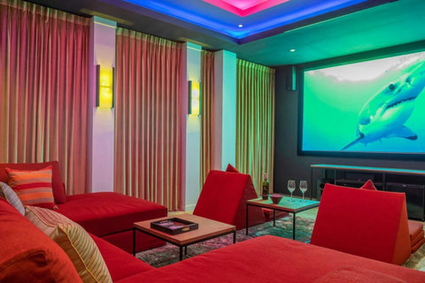 "Enjoy your private cinema room, outfitted with comfy red seating—perfect for movie nights."