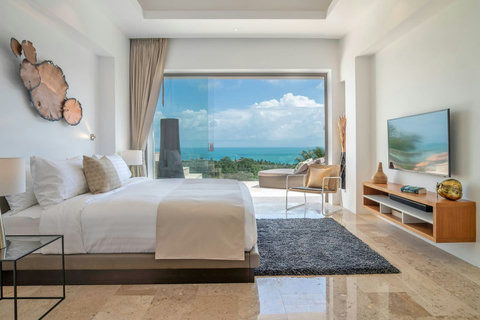 "Elegantly appointed bedroom features sliding glass doors, fine art, a smart TV, and both a ceiling fan and air conditioning for your comfort."
