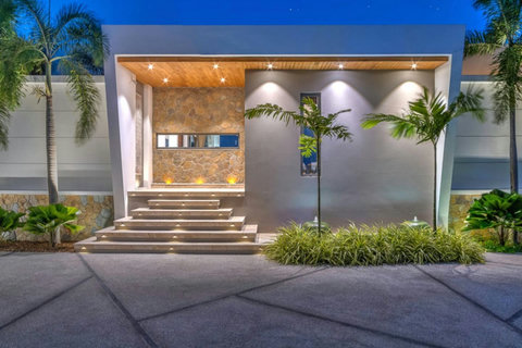 "Nightfall transforms the front entrance of the villa into a beautifully lit gateway to luxury."