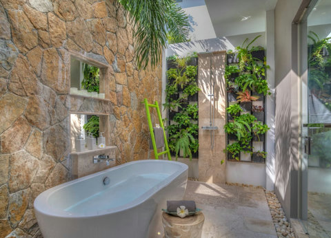 "Bath time becomes a luxurious affair with an open ceiling tub amidst tropical decor."