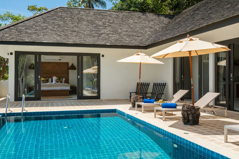 Poolside relaxation with sun loungers, umbrellas and palm trees