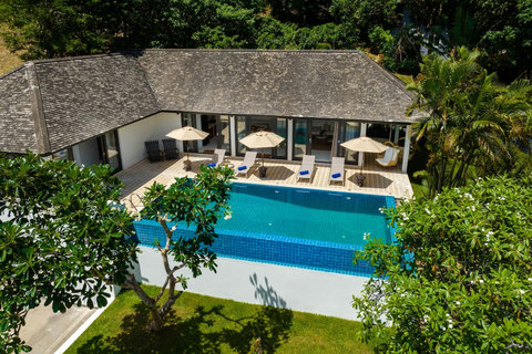 Sparkling private pool with sun loungers and tropical landscaping
