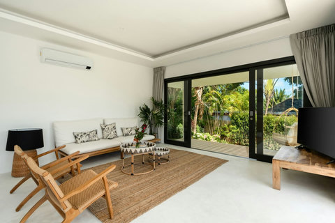 Luxury bedroom with vaulted ceiling and tropical garden views
