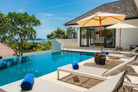 Villa exterior with manicured gardens and blue skies
