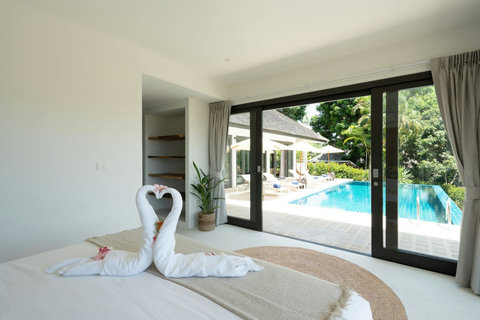 Cozy bedroom with garden access and decorative towel art