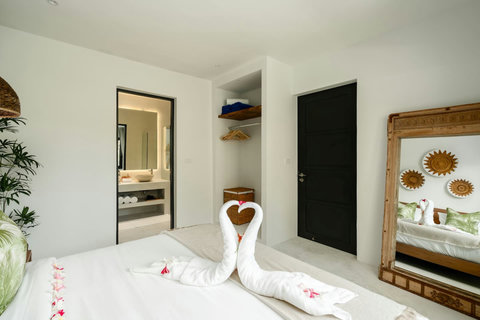 Romantic bedroom with heart-shaped towel art and elegant white decor