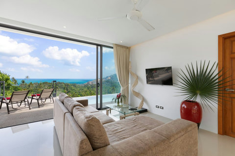 Living area with terrace access offering comfortable furniture, entertainment system and ocean breeze