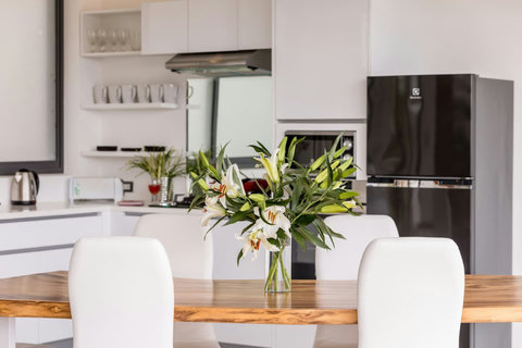 Open-plan kitchen and dining area with space for 8 guests - perfect for family meals and tropical entertaining