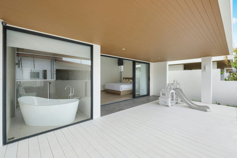 Luxurious en-suite bathroom with freestanding bathtub, modern fixtures and tropical views - spa-like relaxation