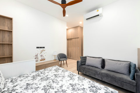 Spacious bedroom with comfortable sofa, study area and cheerful decor - flexible family living space
