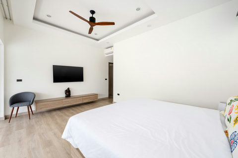 Comfortable bedroom with modern amenities, flat-screen TV and serene atmosphere - perfect family accommodation