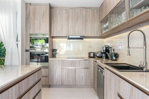 Well-equipped kitchen with modern appliances, ample counter space, storage and garden views - perfect for meal preparation