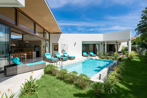 Private pool terrace with turquoise loungers, lush garden and covered outdoor living area - perfect for tropical relaxation