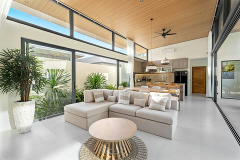 Spacious open-plan living area with soaring ceilings, contemporary design and seamless indoor-outdoor tropical living