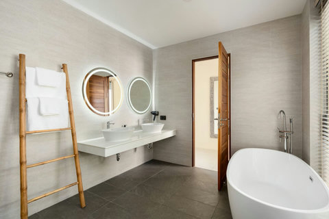 Stylish modern bathroom with soaking tub, double vanity, rainfall shower and contemporary wood accents