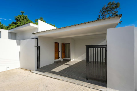 Modern villa exterior with covered parking, sleek white design and tropical surroundings in Samadee Pool Villa project Bophut