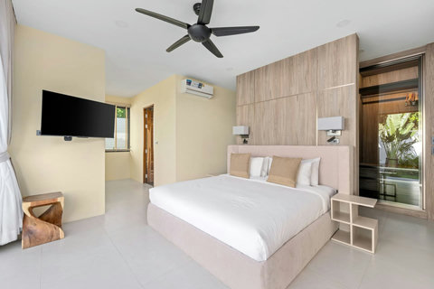Contemporary bedroom with flat-screen TV, modern wood design, air conditioning and plush linens - peaceful retreat