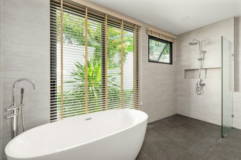 Spa-like bathroom with freestanding soaking tub, rainfall shower, garden window and contemporary design