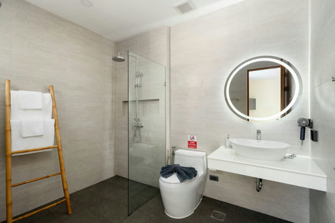 Modern ensuite bathroom with walk-in rainfall shower, circular mirror, vanity and stylish contemporary finishes