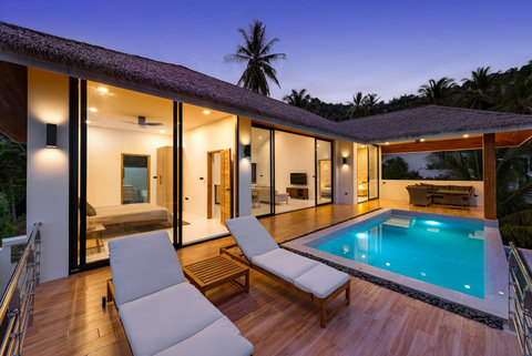 Illuminated pool deck and terrace at dusk - enchanting evening ambiance at Sunrise Hill luxury villa