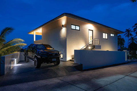 Villa exterior illuminated at night with modern architectural lighting - sophisticated evening elegance