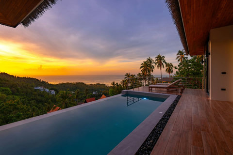 Spectacular sunset infinity pool with tropical jungle and ocean horizon - breathtaking luxury villa Koh Samui