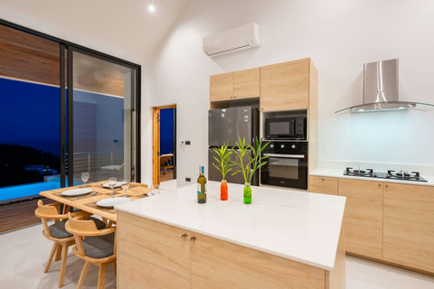 Gourmet kitchen with premium appliances and pool views - modern Koh Samui hillside villa luxury living
