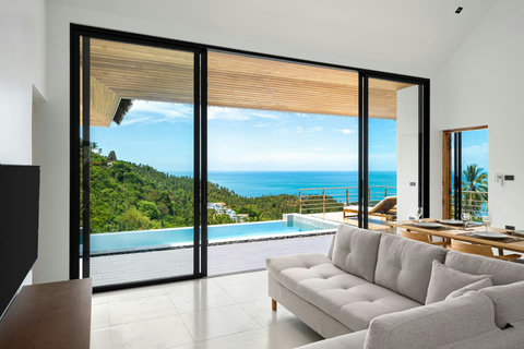 Elegant open-plan living room with floor-to-ceiling windows and spectacular sea views - Sunrise Hill villa luxury