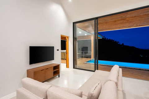 Bedroom with illuminated pool view at dusk - modern luxury villa with terrace access