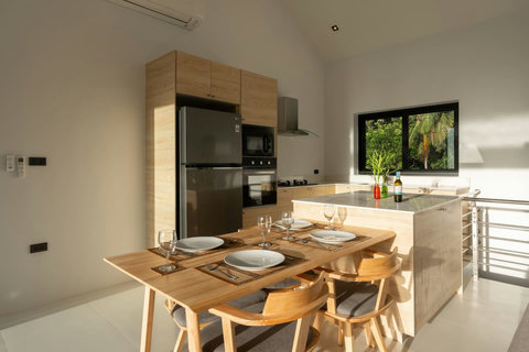 Modern open plan kitchen and dining area with island, garden views - contemporary luxury villa