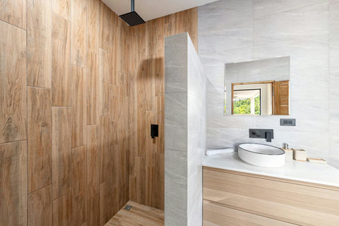 Contemporary bathroom with wood paneling and modern fixtures - spa-like luxury villa bathroom