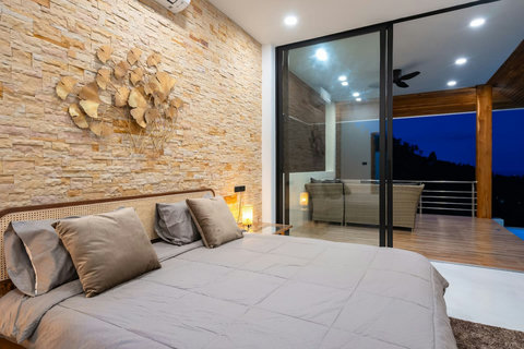 Bright bedroom with terrace access and tropical garden views - serene hillside accommodation