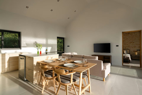 Elegant dining area with wooden table for 8 and open kitchen - perfect family gathering space