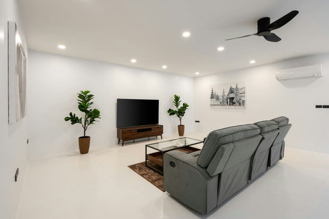 Contemporary living room with modern furnishings, entertainment area and ceiling fan - comfortable indoor living space