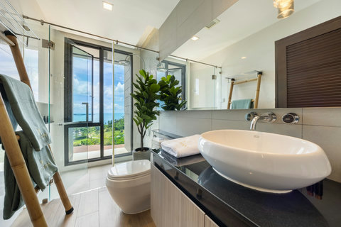 Bathroom with freestanding bathtub and floor-to-ceiling windows with sea views at Villa Yoco, Koh Samui