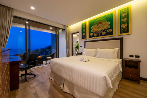 Bedroom at dusk with artwork, sea-view balcony and cozy lighting at Villa Yoco, Koh Samui