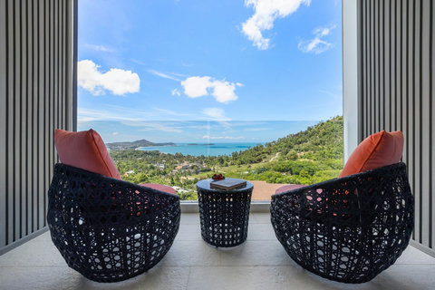 Private balcony with rattan chairs and panoramic sea views at Villa Yoco, Koh Samui