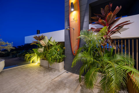 Tropical garden entrance with lush planting illuminated at dusk at Villa Yoco, Koh Samui