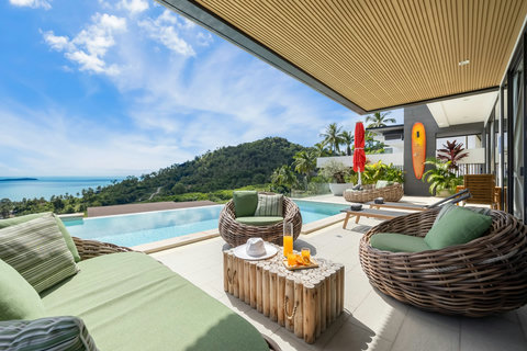 Covered poolside terrace with rattan seating and sea views at Villa Yoco, Koh Samui