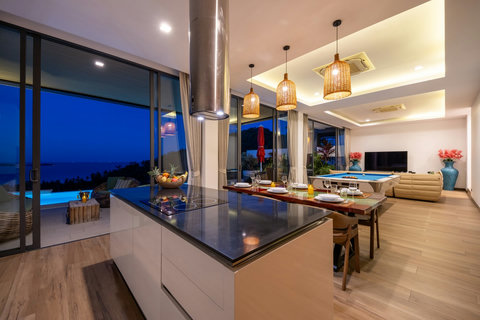 Open-plan kitchen and dining island at dusk with sea views at Villa Yoco, Koh Samui