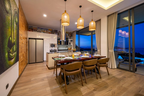 Dining table set for six with pendant lighting and sea views at Villa Yoco, Koh Samui