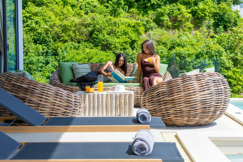 Guests relaxing on the poolside sofa surrounded by greenery at Villa Yoco, Koh Samui