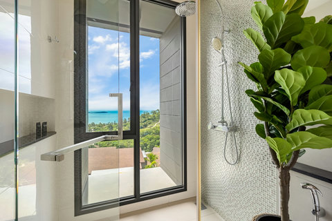 Walk-in rain shower with sea views and natural light at Villa Yoco, Koh Samui