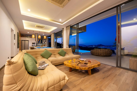 Living room at dusk with sea views, comfortable sofa and coffee table at Villa Yoco, Koh Samui